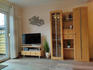 sala de estar con TV y armario en Ferienhaus Schulte, en Carolinensiel