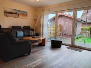 una sala de estar con un sofá y una mesa en Ferienhaus Schulte, en Carolinensiel