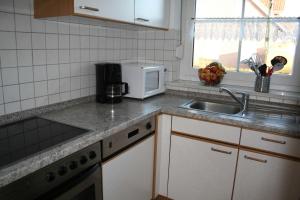una cocina con fregadero y microondas en Ferienhaus Schulte, en Carolinensiel 4 fotos más