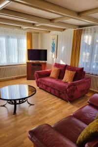 - un salon avec un canapé rouge et une table dans l'établissement Apartment Lilo-4-Zimmer by Interhome, à Beatenberg