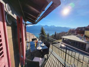 d'un balcon avec une table et une vue sur les montagnes. dans l'établissement Apartment Lilo-4-Zimmer by Interhome, à Beatenberg