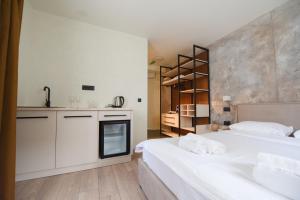 a bedroom with a large white bed and a kitchen at Iva Old Town in Belgrade