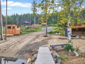 a dirt road with a house and a wooden bridge at Holiday Home Kolin kangastus metsätähti 2 by Interhome in Kolinkylä
