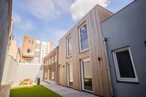 a wooden building with a green lawn in front of it at Fancy 70m2 Apartment with Terrace - WE39F in Tiel