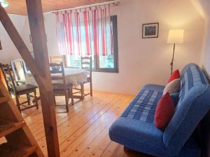 a living room with a blue couch and a table at Chalet The Fox by Interhome in Zlobin