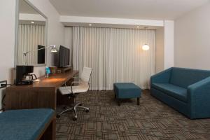 a hotel room with a desk and a blue couch at Hampton Inn by Hilton Hermosillo in Hermosillo