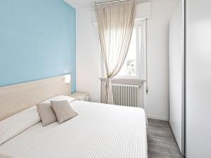 a bedroom with a white bed and a window at Apartment Rimini Mare by Interhome in Rimini
