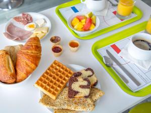uma bandeja de alimentos de pequeno-almoço numa mesa em Ibis Budget Fréjus St Raphaël centre et plages à 900m em Fréjus