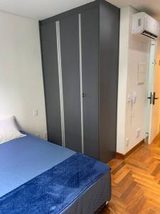 a bedroom with a blue bed and a closet at Studio na Bela Vista in Sao Paulo