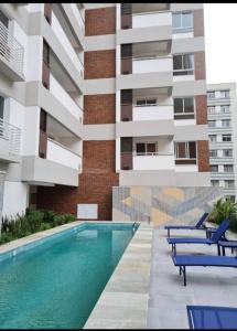 a building with a swimming pool in front of a building at Studio na Bela Vista in Sao Paulo