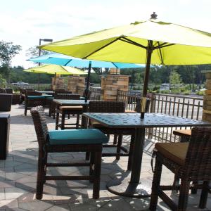 una mesa y sillas con una sombrilla en el patio en Hampton Inn & Suites Stroudsburg Bartonsville Poconos en Stroudsburg