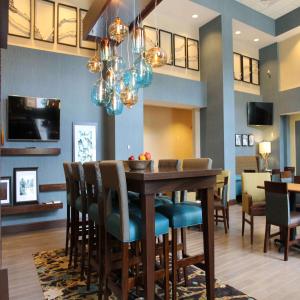 uma sala de jantar e sala de estar com mesa e cadeiras em Hampton Inn & Suites Stroudsburg Bartonsville Poconos em Stroudsburg