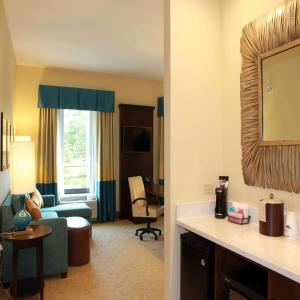 een kamer met een woonkamer met een bank en een stoel bij Hampton Inn & Suites Stroudsburg Bartonsville Poconos in Stroudsburg