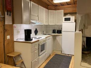 Il comprend une cuisine équipée d'appareils électroménagers blancs et d'un réfrigérateur blanc. dans l'établissement Holiday Home Rinnekero 3 a by Interhome, à Pyhätunturi