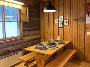 une table en bois dans une cabane en bois avec une salle à manger dans l'établissement Holiday Home Rinnekero 3 a by Interhome, à Pyhätunturi