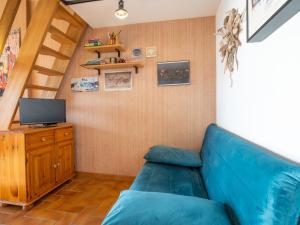 salon z niebieską kanapą i telewizorem w obiekcie Apartment La Gaillarde-16 by Interhome w mieście Les Issambres