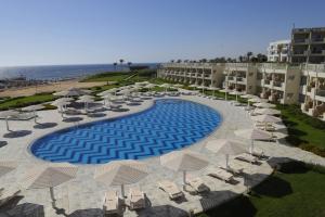 una vista sul mare di un resort con piscina, sedie e ombrelloni di SIRENA BEACH RESORT & SPA a Marsa Alam