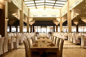 a dining room with a long table and white chairs at SIRENA BEACH RESORT & SPA in Marsa Alam City