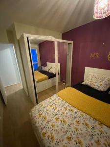 um quarto com uma cama e um espelho grande em T2 entier Chambre+Salon+Cuisine em Les Ulis