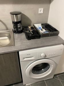 um balcão de cozinha com uma máquina de lavar roupa e um lavatório em T2 entier Chambre+Salon+Cuisine em Les Ulis