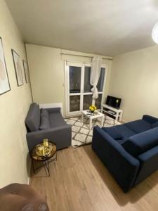 uma sala de estar com dois sofás azuis e uma janela em T2 entier Chambre+Salon+Cuisine em Les Ulis