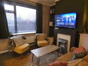 uma sala de estar com lareira e televisão em Comfy 3 Bedroom Cottage in a Calm Location em Abertillery