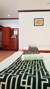 a bedroom with a bed with a black and white rug at HMC Guesthouse - Malapascua Island Air-conditioned Room #2 in Logon