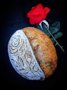 a loaf of bread next to a red rose at Tranquility Stay in Hanoi