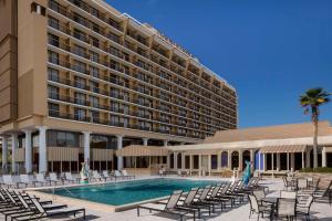 een hotel met een zwembad en stoelen en een gebouw bij DoubleTree by Hilton Jacksonville Riverfront, FL in Jacksonville