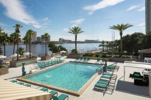 una piscina con sillas y vistas al agua en DoubleTree by Hilton Jacksonville Riverfront, FL en Jacksonville