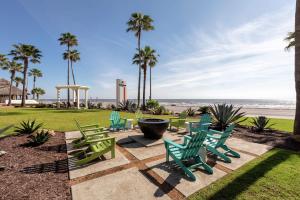 a group of lawn chairs and a fountain and the beach at DoubleTree by Hilton Galveston Beach in Galveston