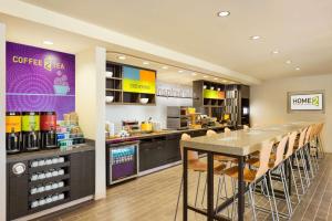 a kitchen with a table and chairs in a restaurant at Home2 Suites by Hilton Farmington/Bloomfield in Farmington