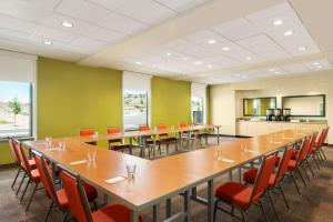 Home2 Suites by Hilton Farmington/Bloomfield في فارمينغتون: قاعة اجتماعات كبيرة مع طاولات وكراسي