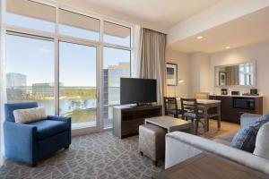 a living room with a couch and a television and a table at Embassy Suites by Hilton The Woodlands in The Woodlands