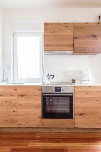 a kitchen with wooden cabinets and a black oven at Terasse Jeruzalem Apartments in Hermanci