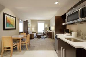 a kitchen with a table and a dining room at Home2 Suites by Hilton Fort Smith in Fort Smith