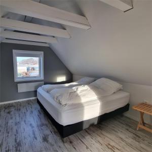 1 dormitorio con 1 cama en una habitación con ventana en Igdlo Guesthouse, en Narsaq
