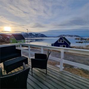 a deck with chairs and a view of a body of water at Igdlo Guesthouse in Narsaq
