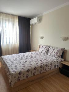 - une chambre avec un lit et une couette à fleurs dans l'établissement Sea View Sarafovo, à Sarafovo