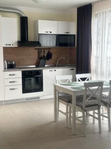 une cuisine avec une table et des chaises et une cuisine avec des placards blancs dans l'établissement Sea View Sarafovo, à Sarafovo
