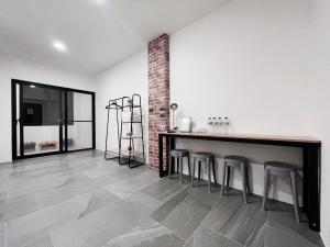 a room with a bar with stools and a brick wall at Xianqing Yizhi Homestay in Taitung City