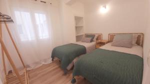 1 dormitorio con 2 camas con sábanas verdes y blancas en Del Parque Flats Alemania Soho, en Málaga