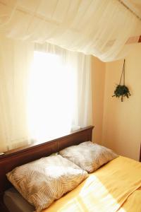 a bed in a bedroom with a large window at Apartament ZAMURNA 4 in Golub-Dobrzyń