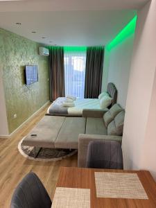 duas camas num quarto com iluminação verde em Luxury Apartment Tirana em Tirana