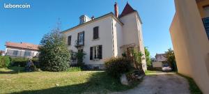 a white house with a car parked in front of it at LE BALI in Besançon
