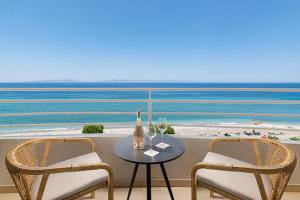 a table and chairs with a view of the beach at Electra Palace Rhodes - Premium All Inclusive in Ialyssos