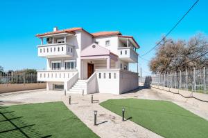 una casa blanca con un campo de golf delante de ella en Villa Elida 