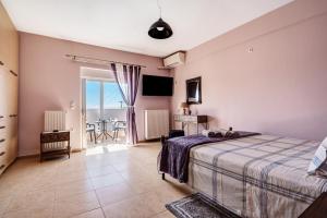 a bedroom with a bed and a balcony with a table at Villa Elida 