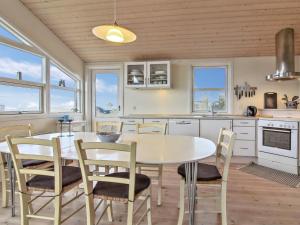 uma cozinha com uma mesa de jantar e cadeiras em Holiday Home Florida - 100m from the sea in NW Jutland by Interhome em Lokken