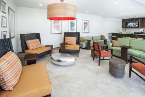 una sala d'attesa con un mucchio di sedie e tavoli di Hilton Garden Inn Jackson/Flowood a Flowood